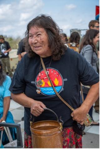 Photo of Josephine Mandamin carrying the copper pail